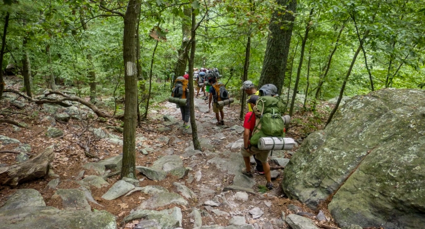 a group of veterans navigate a rocky trail on an outward bound expedition 